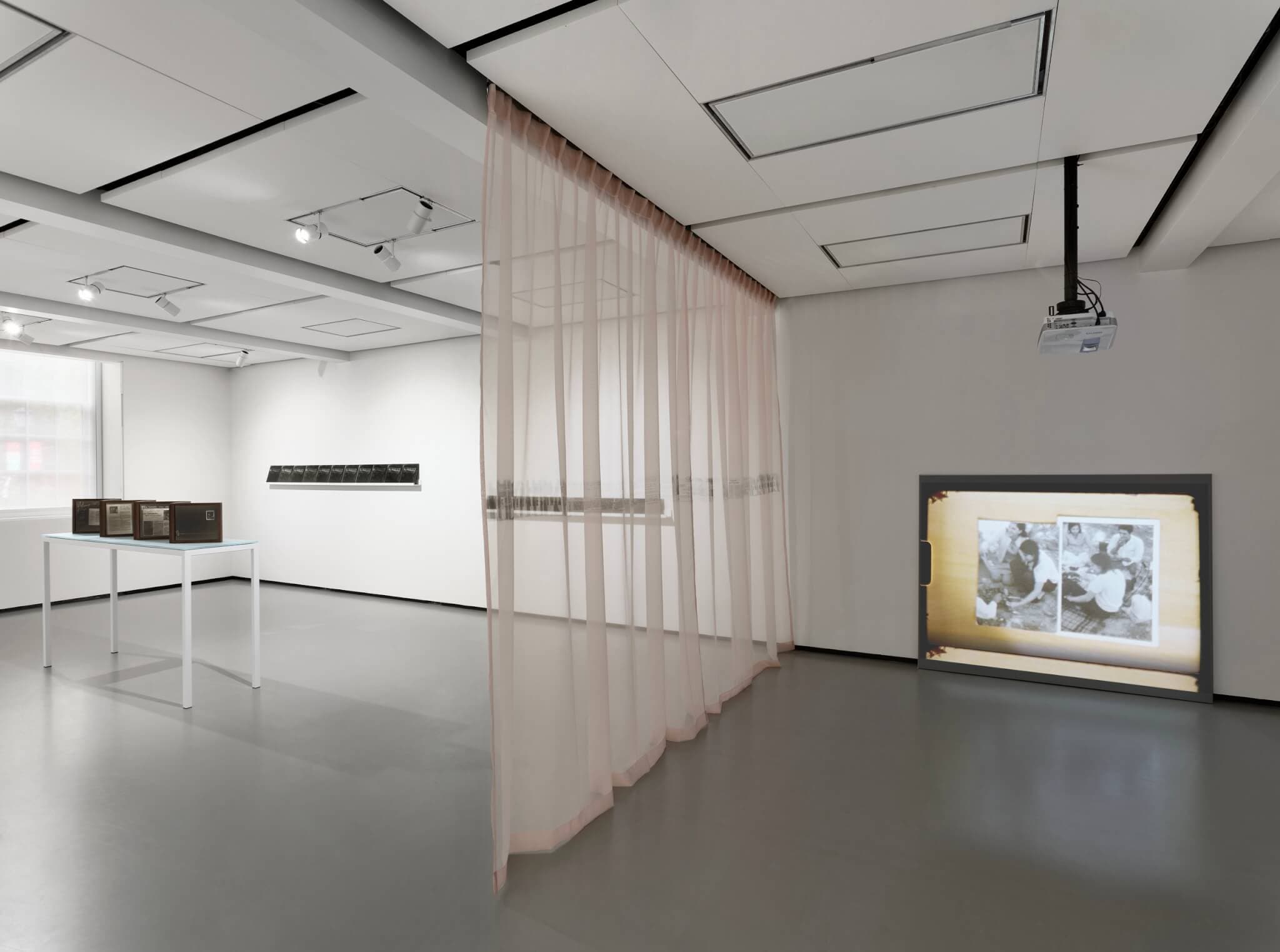 A single-channel video, a translucent screen, and works printed on mirrors in a gallery.