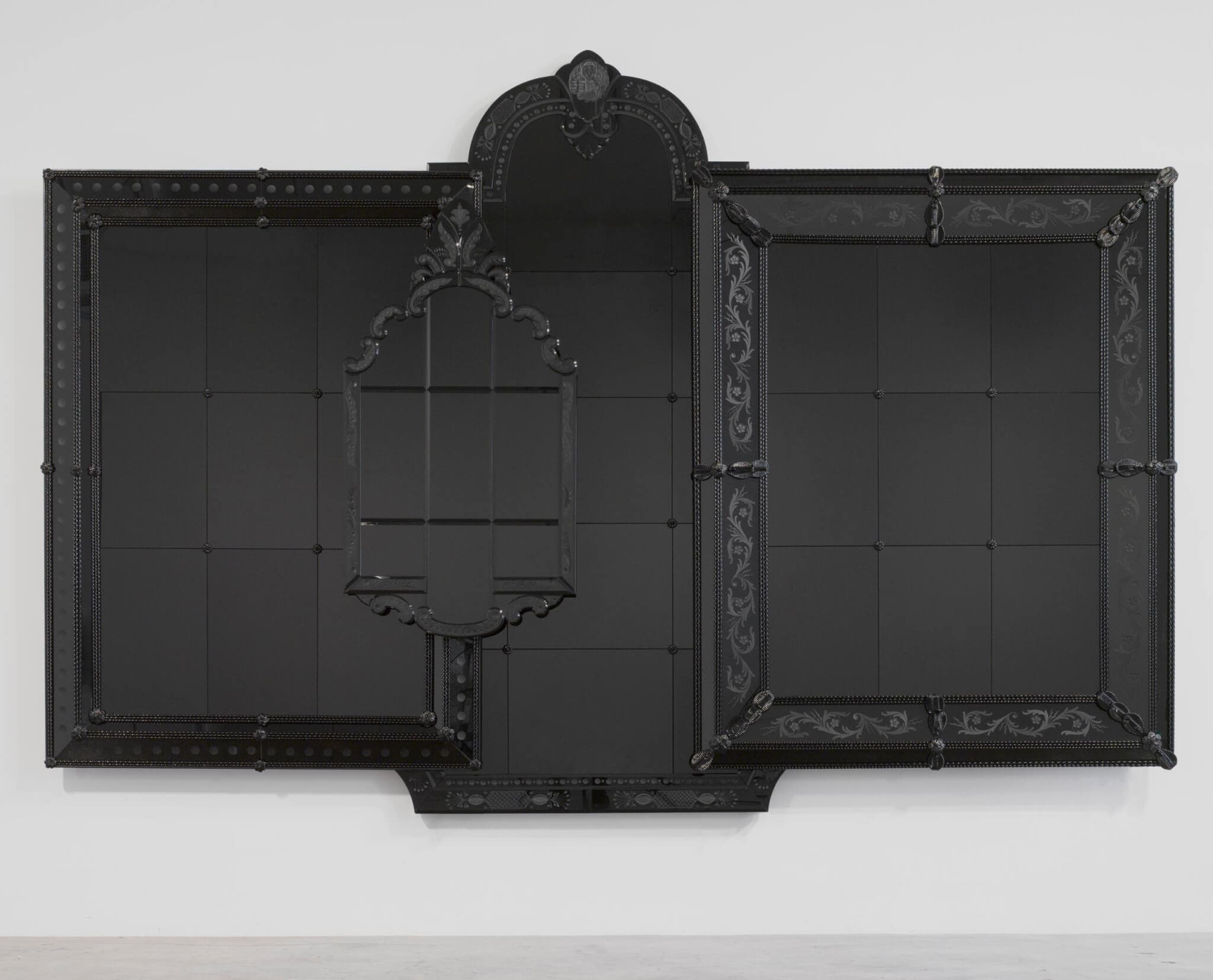 A black Murano glass mirror framed in wood.